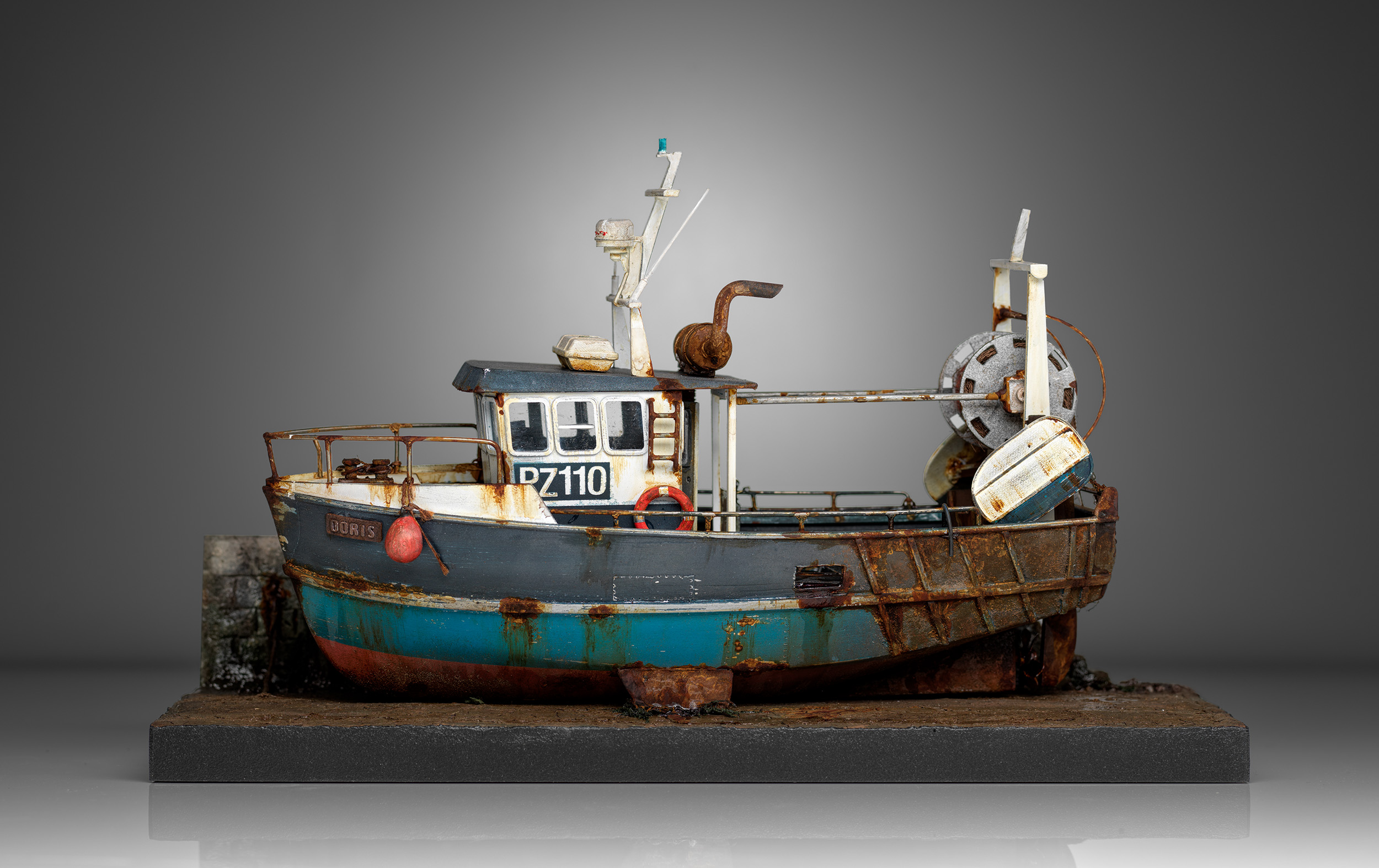 Side view of Doris with her turquoise lower hull, net drum and weathered stern